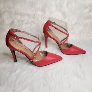 Pointed toe red heels with studded straps.
